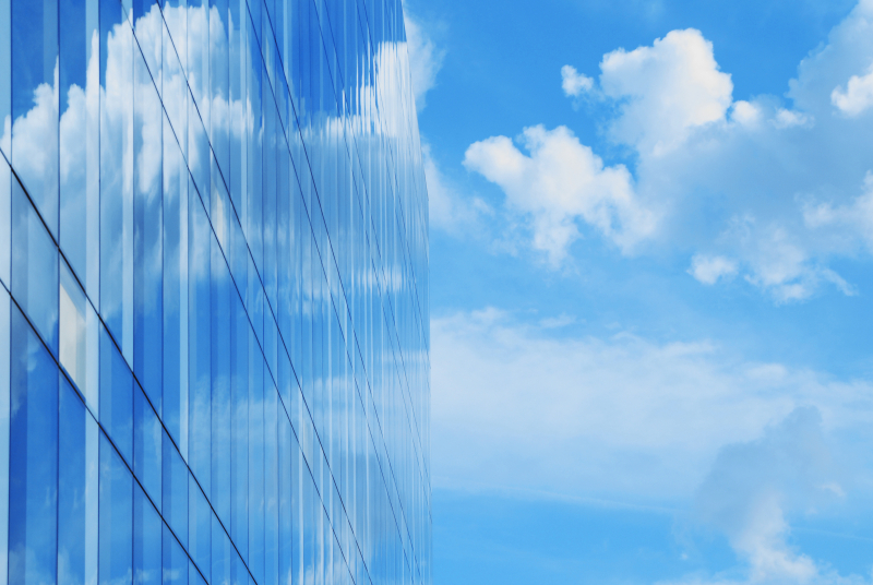 A modern glass office builidng reflects blue sky and clouds indicating environmental architecture or a business intent to reduce greenhouse gas emissions. ©  Istockphoto.com / WWF-Canada