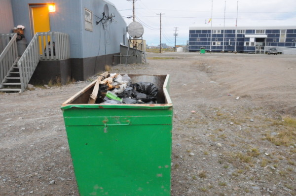 Garbage sits in an open bin on the street. This is an invitation to Polar bears (Ursus maritimus) who are hungry at this time of the year and are forced to wait longer for the ice to form so they can go out to hunt. Resolutions are sought to these conflicts between humans and polar bears. Arviat, Nunavut, Canada. © Peter Ewins / WWF-Canada