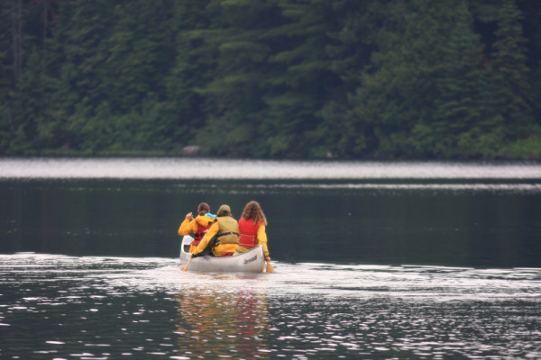 Canoeists paddle on an Algonquin Provincial Park lake, Ontario, Canada.