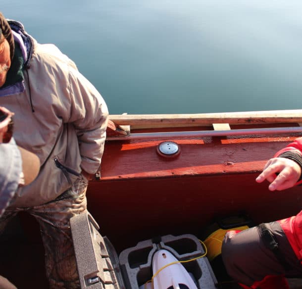 Researcher David Deslauriers and harvesters Lucassie Arragutainaq and Noah Meeko discuss underwater video equipment