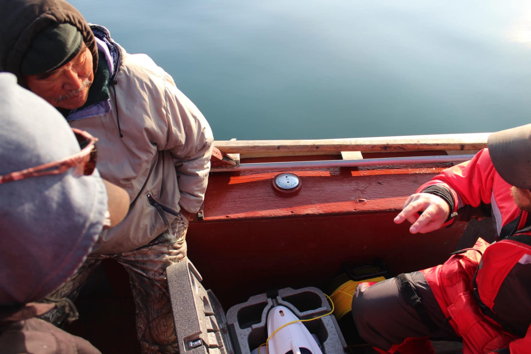 Researcher David Deslauriers and harvesters Lucassie Arragutainaq and Noah Meeko discuss underwater video equipment