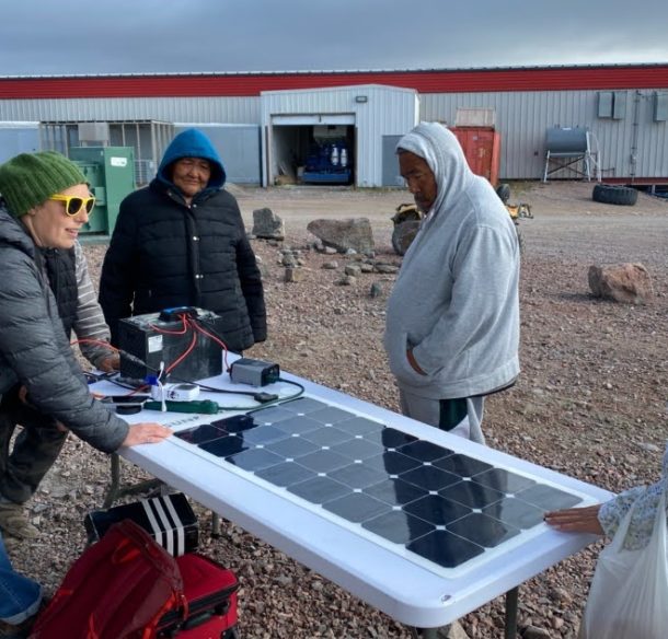 Group standing around solar panels in Nunavut