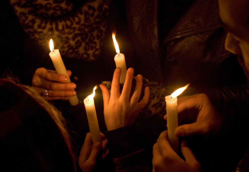 Earth Hour 2009. Hands holding candles.