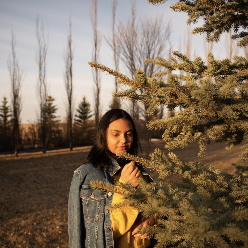 Teenage woman standing in a forest