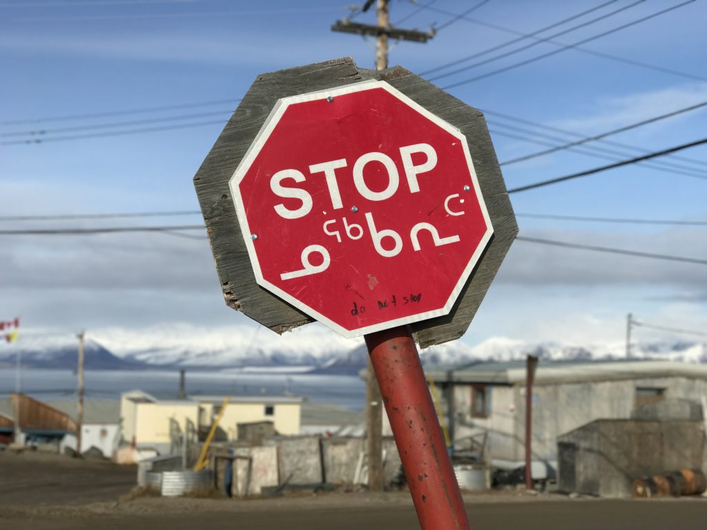 Inuktitut and English stop sign in Pond Inlet, Nunavut