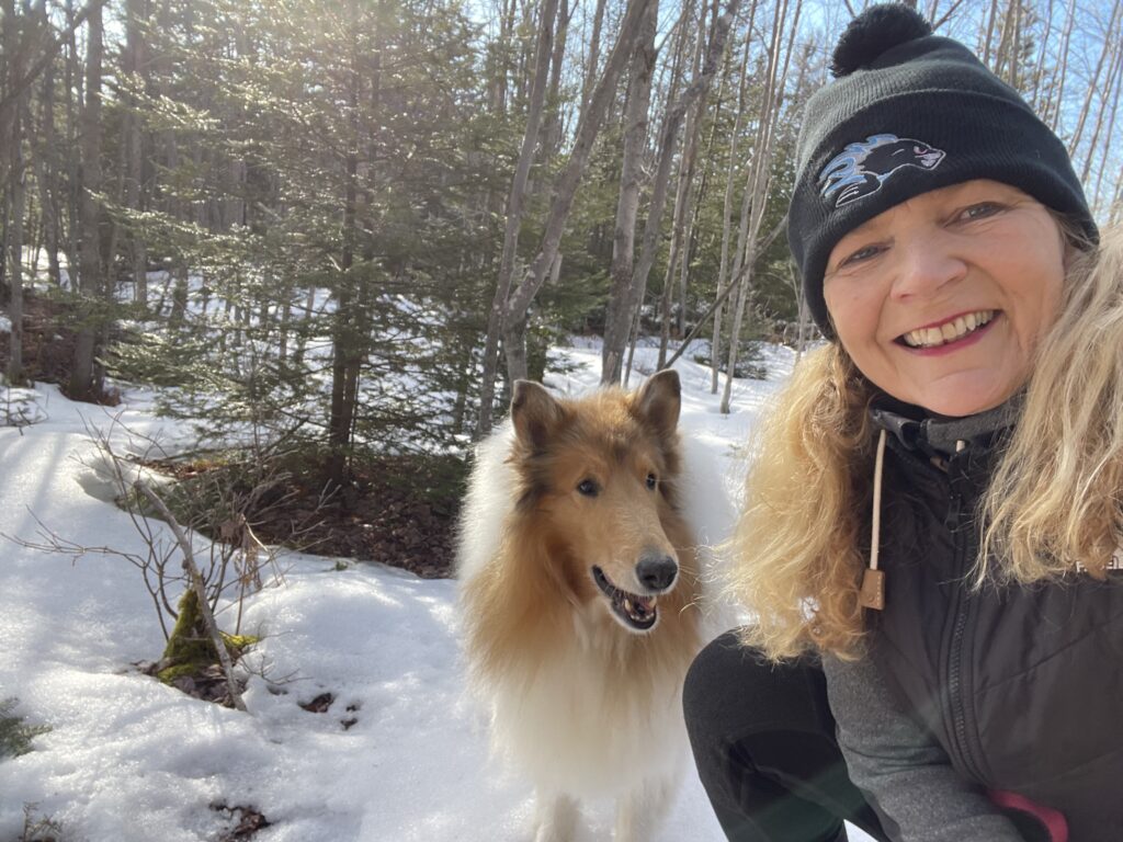 Kristina posing outside in the snow with a border collie