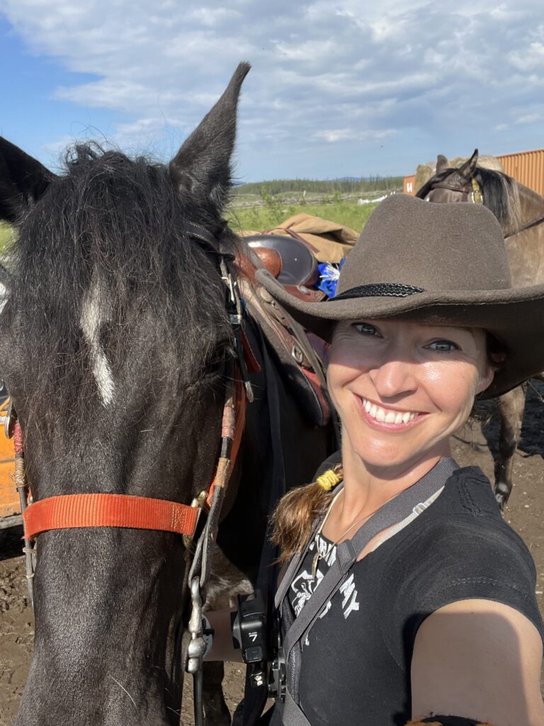 Victoria Gort from Victoria B.C., smiling with a brown horse. 