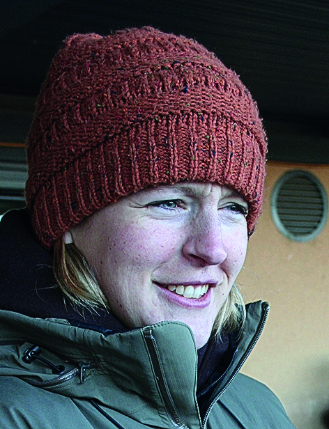 Woman in green parka and dark orange toque 