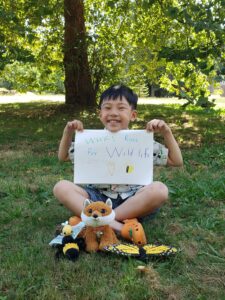 Young boy holds up a handmade "Race for Wildlife" sign