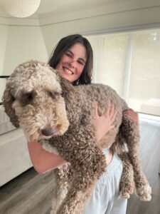 Woman holding a brown dog in her arms.