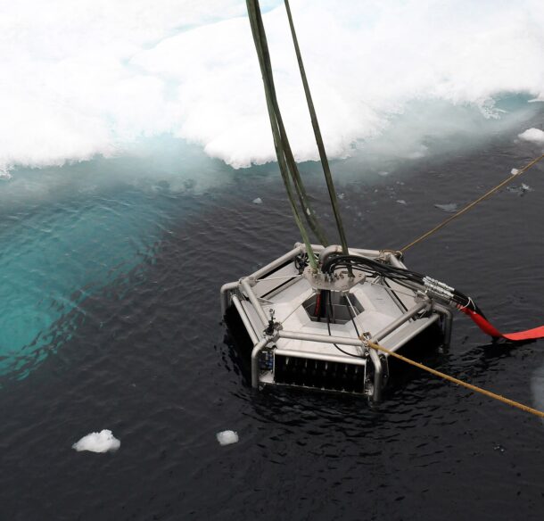 An oil skimmer floats near an ice floe edge