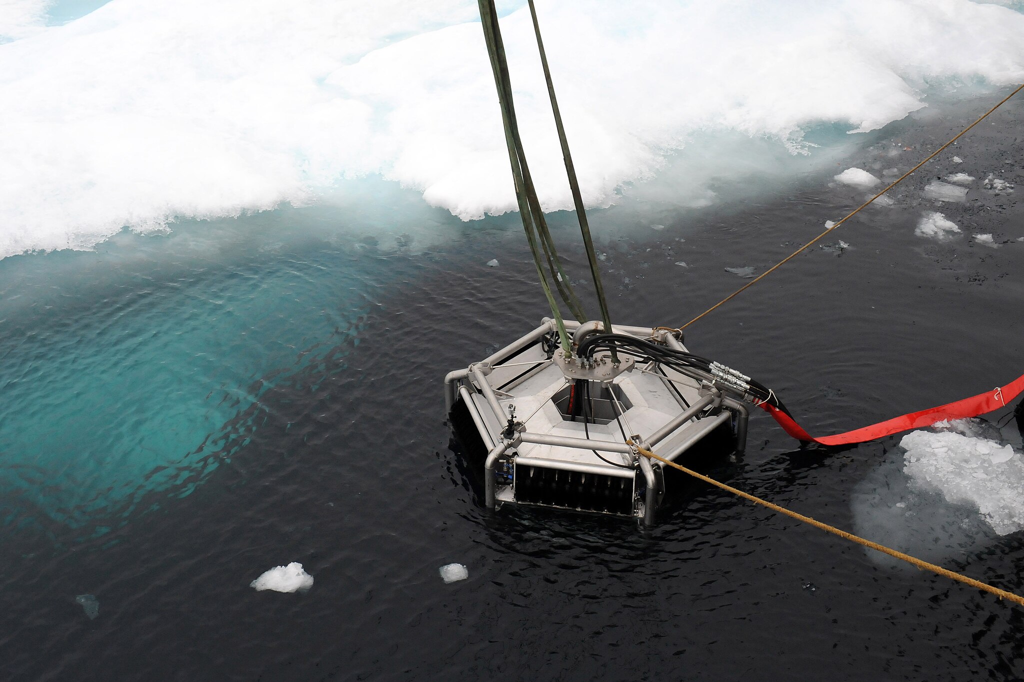 An oil skimmer floats near an ice floe edge