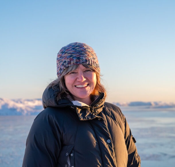 Woman, smiling, in a sunny arctic landscape during winter