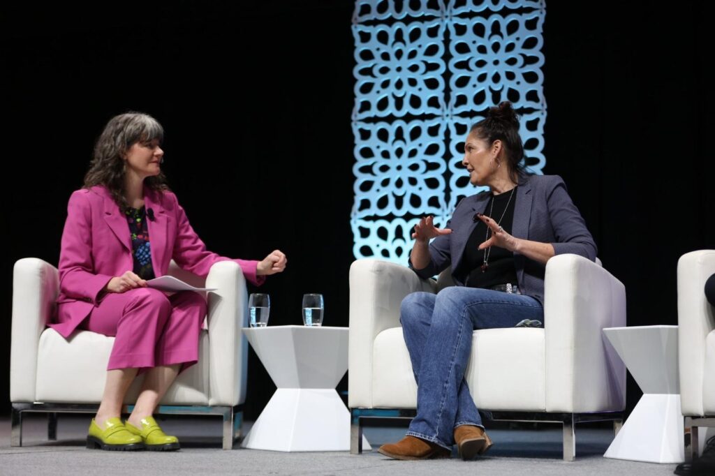 Two women on white chairs at GLOBE Forum in Vancouver. 