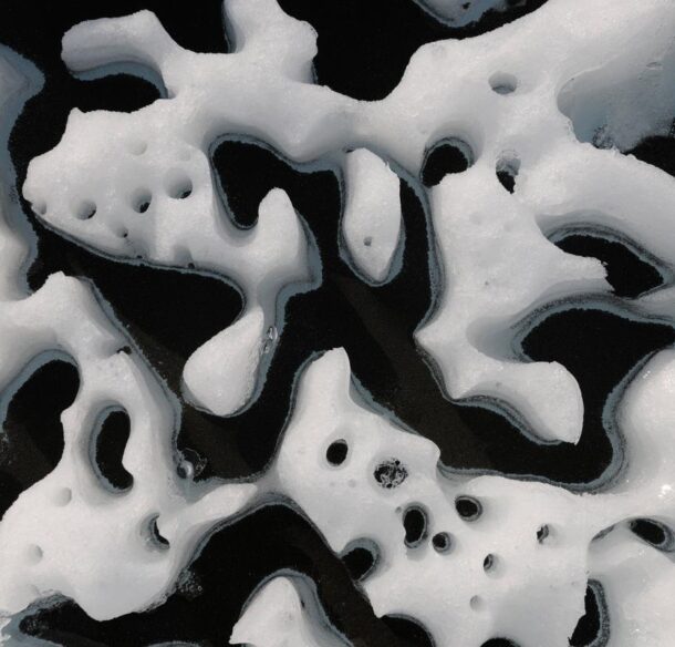 Close-up image of ice melting around black particulate matter