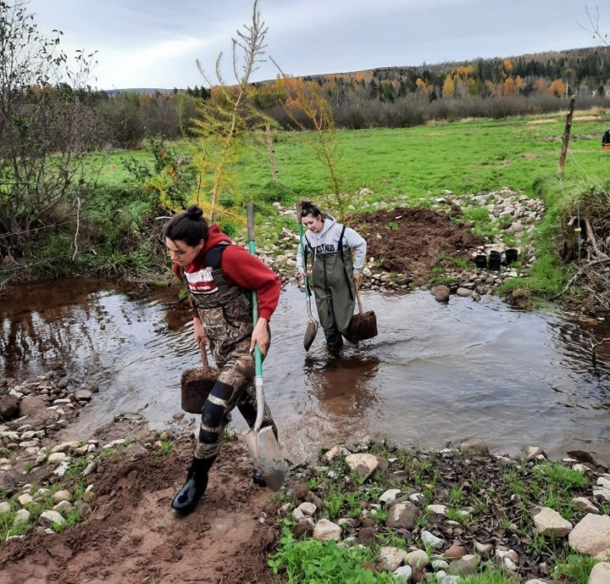 Staff members, Ashton Howe and Brooklynne King shuttle trees to a planting site along Passekeag Creek at the Gaunce farm