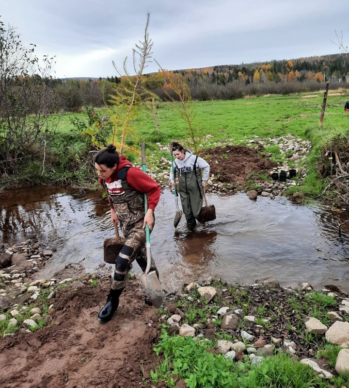 Staff members, Ashton Howe and Brooklynne King shuttle trees to a planting site along Passekeag Creek at the Gaunce farm