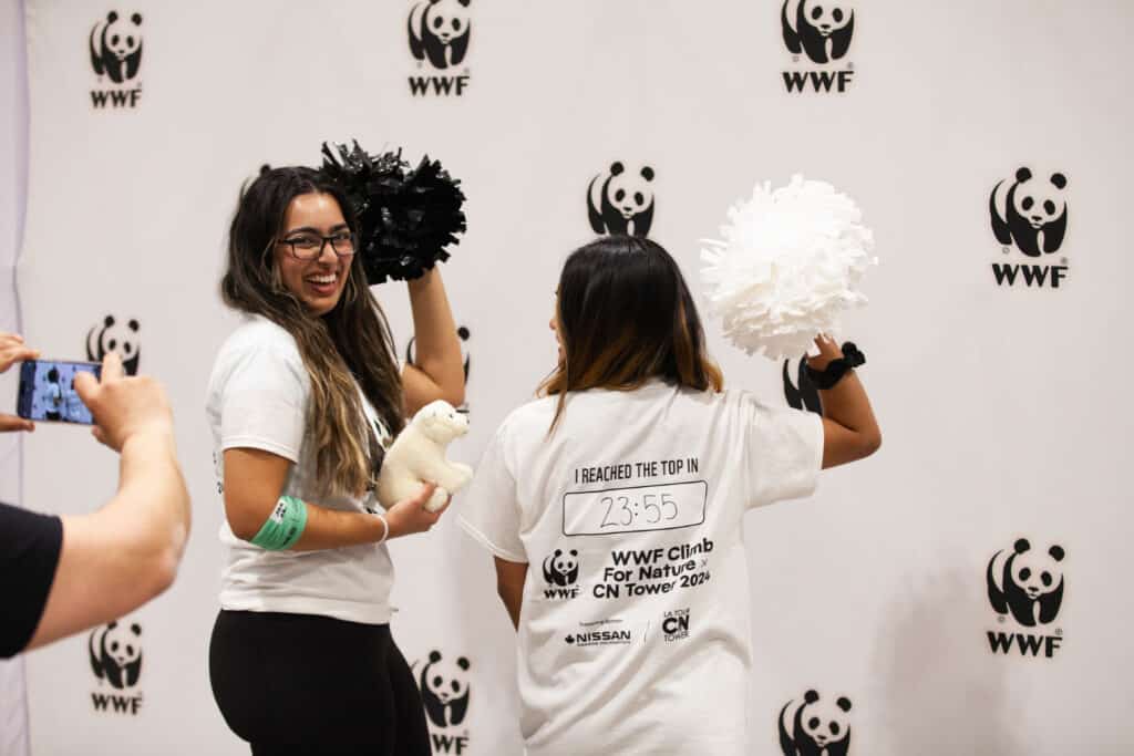 Two people celebrate climbing the CN Tower by showing the times on the back of their T-shirts.